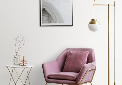 Picture frame with abstract art by a pink velvet armchair